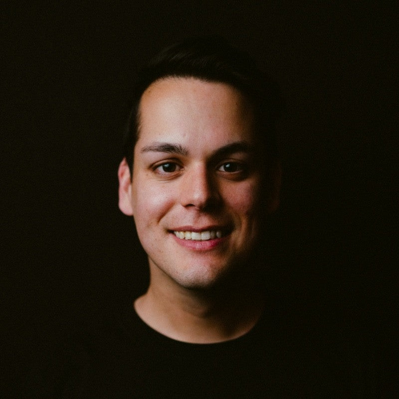 Man smiling against a dark background